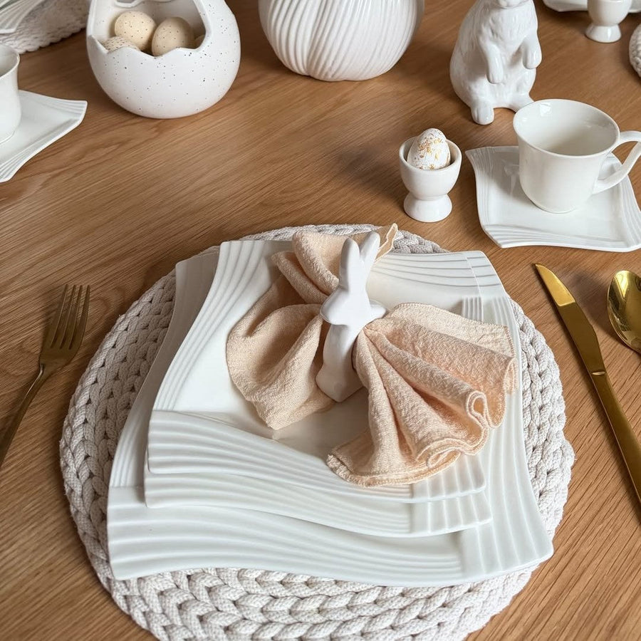 Blooming Easter tablescape with white porcelain dinnerware, styled with pastel colors, spring flowers, and elegant table decor for a fresh seasonal table setting