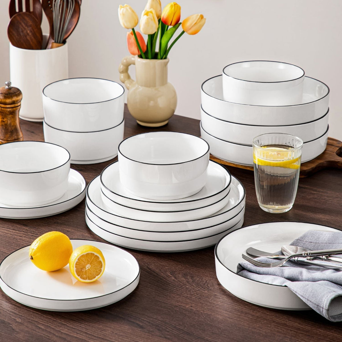 Stacked dinnerware service for 12 with plates, bowls, and mugs arranged for cabinet storage and dining table planning.