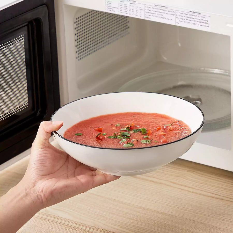 A high-fired ceramic bowl being heated in a microwave while discussing why microwave-safe bowls get hot during everyday reheating.